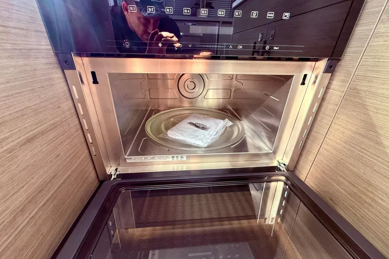 Slide: The Image of 2024 Jeanneau NC 1295 Fly kitchen microwave interior with digital controls. - 19