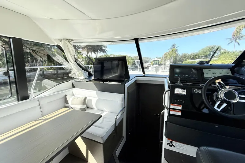 Slide: The Image of 2024 Jeanneau NC 1295 Fly interior with helm, seating, and panoramic windows. - 21