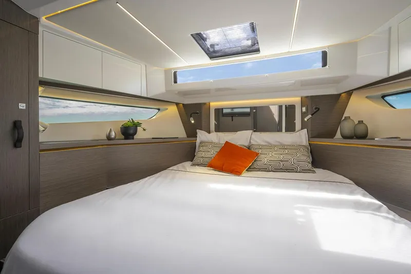 Slide: The Image of 2024 Jeanneau NC 1295 Fly yacht flybridge with seating and table, docked by waterfront homes. - 7
