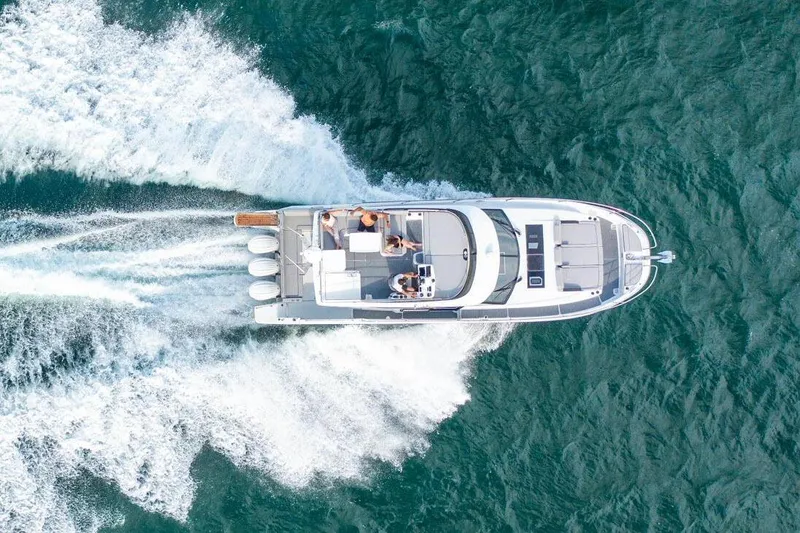 Slide: The Image of 2024 Jeanneau NC 1295 Fly yacht docked by a serene waterfront. - 9