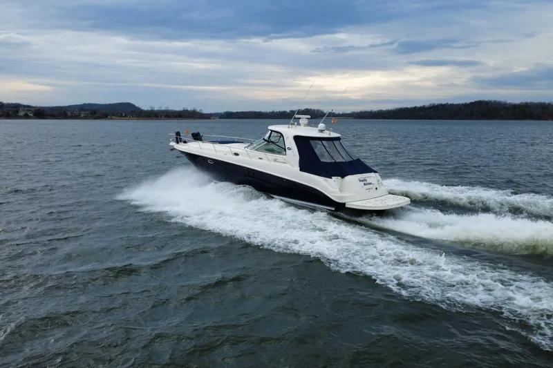 Slide: The Image of 2004 Sea Ray Sundancer 460 cruising on a lake under a cloudy sky. - 11
