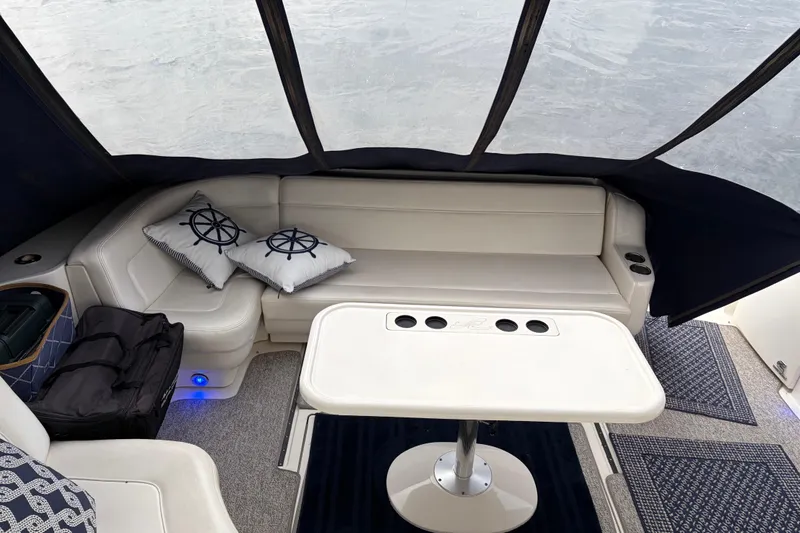 Slide: The Image of 2004 Sea Ray Sundancer 460 interior with cushioned seating, nautical pillows, and a central table. - 18