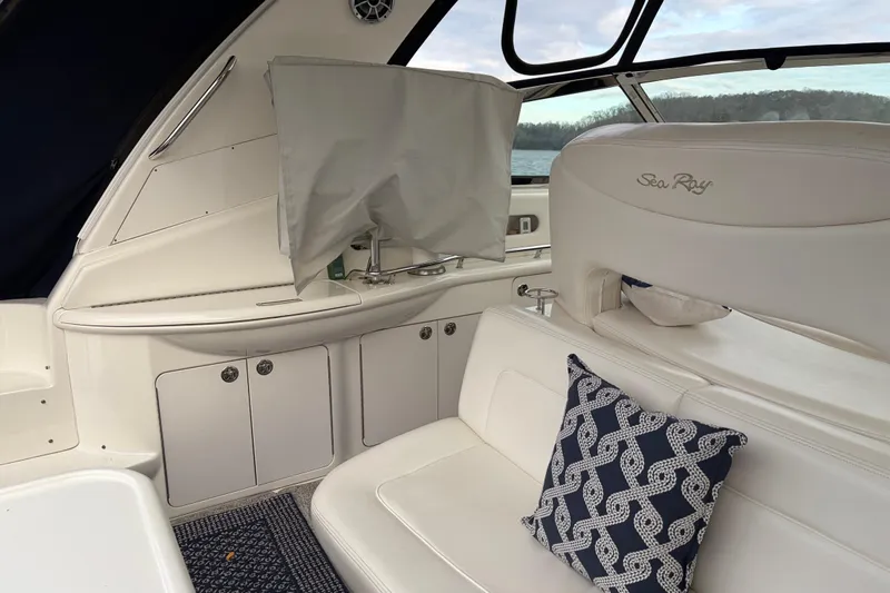 Slide: The Image of 2004 Sea Ray Sundancer 460 interior with white seating and nautical-themed pillow. - 23