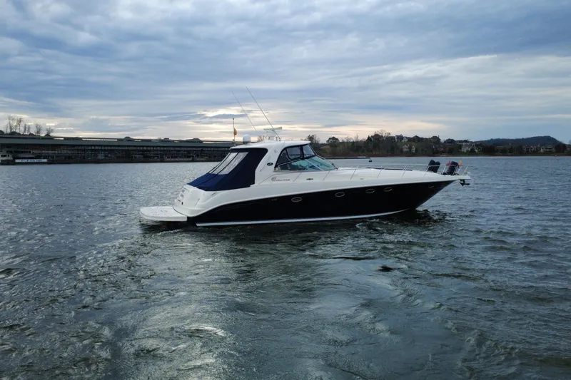 Slide: The Image of 2004 Sea Ray Sundancer 460 yacht cruising on a calm lake under a cloudy sky. - 8