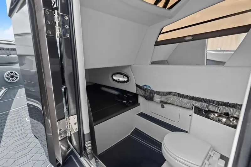 Slide: The Image of 2023 Nor-Tech 390 Sport Center Console cabin interior with seating and toilet. - 14