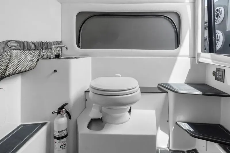 Slide: The Image of 2023 Nor-Tech 390 Sport Center Console interior bathroom with toilet and sink. - 17