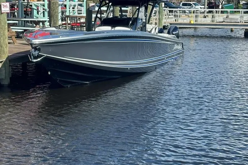 Slide: The Image of 2023 Nor-Tech 390 Sport Center Console boat docked on calm water. - 19