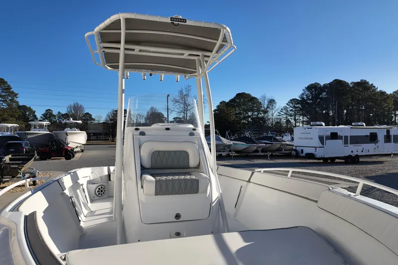 Slide: The Image of 2025 ALK2 Powerboats 23 CRX with T-top, parked outdoors under clear blue sky. - 11