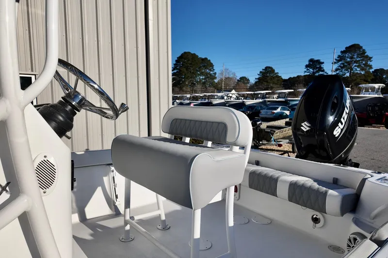 Slide: The Image of 2025 ALK2 Powerboats 23 CRX interior with steering wheel and Suzuki outboard motor. - 13