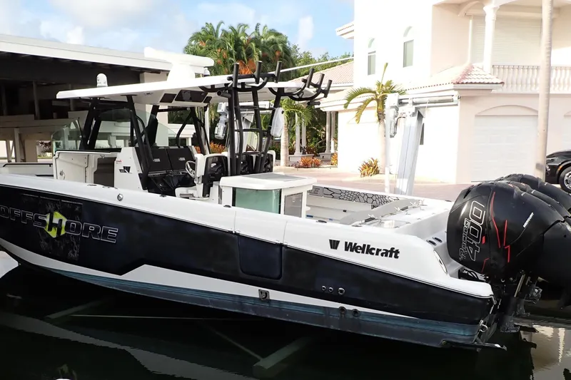 The Image of 2019 Wellcraft 352 Fisherman boat docked near a waterfront home. - 1