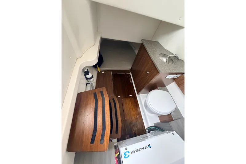Slide: The Image of 2019 Wellcraft 352 Fisherman cabin interior with sink, toilet, and wooden flooring. - 11