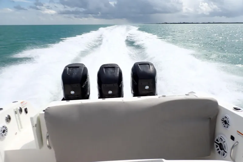 Slide: The Image of 2019 Wellcraft 352 Fisherman boat with triple outboard engines cruising on open water. - 14