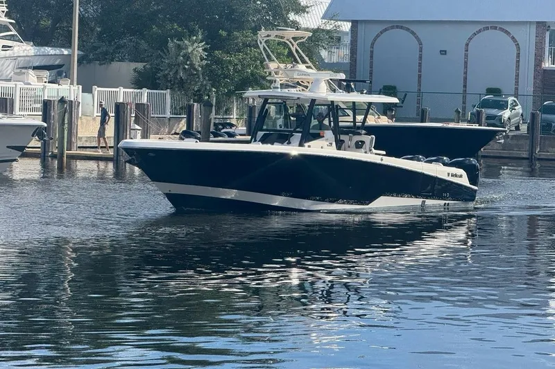 Slide: The Image of 2019 Wellcraft 352 Fisherman boat docked in a marina, reflecting on calm water. - 3