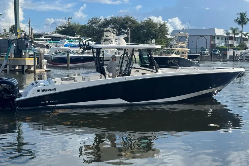 Slide: The Image of 2019 Wellcraft 352 Fisherman boat docked in a marina, clear sky background. - 5