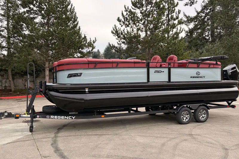 Slide: The Image of 2026 Regency 250 DL pontoon boat on trailer, featuring red seating and sleek design. - 2