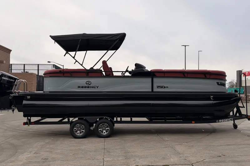 Slide: The Image of 2026 Regency 250 DL pontoon boat on trailer, featuring a sleek design and canopy. - 3