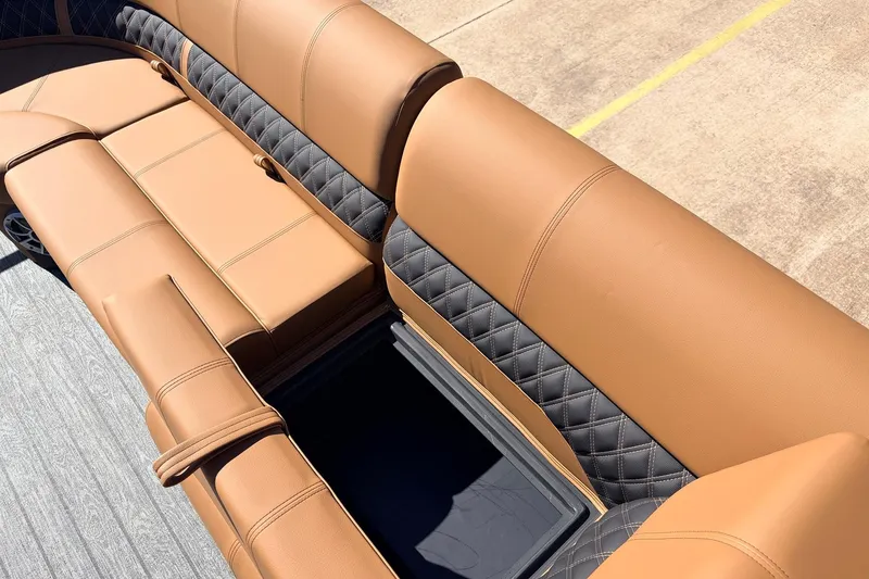 Slide: The Image of 2026 Ranger 223FC boat seating with tan and black quilted upholstery, open storage compartment. - 15