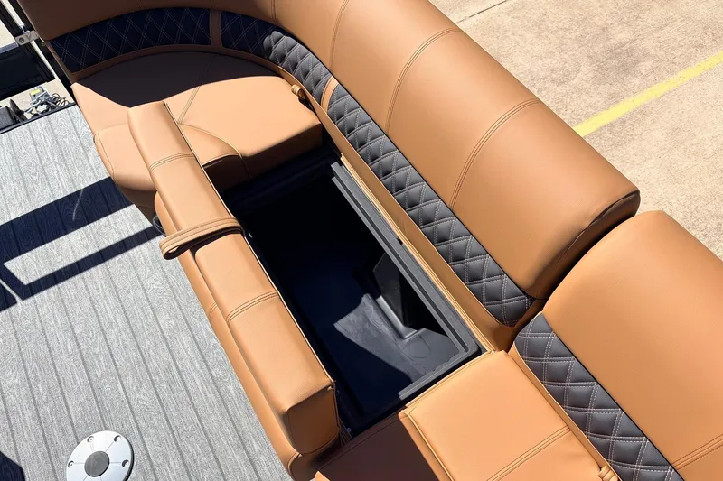 Slide: The Image of 2026 Ranger 223FC boat with tan and black quilted seating and storage compartment. - 16