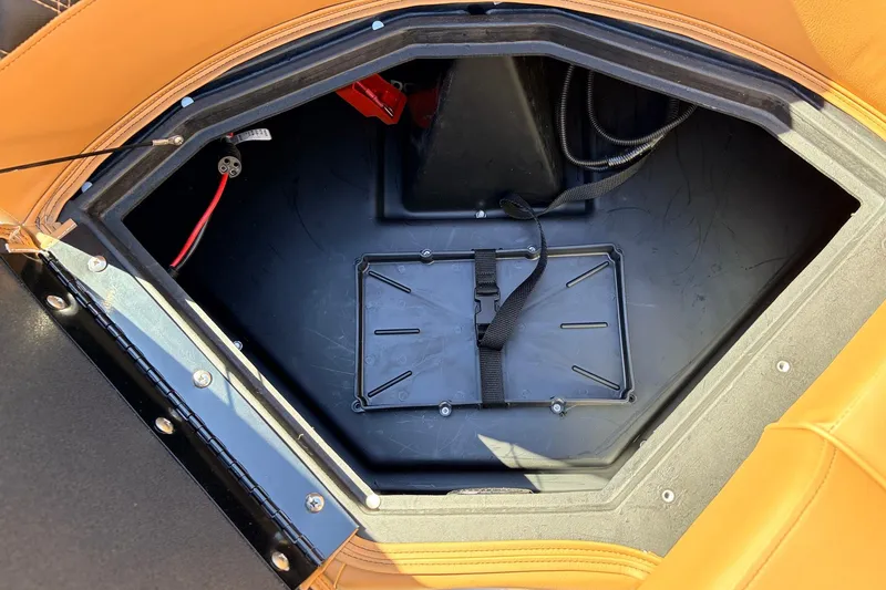 Slide: The Image of Open storage compartment in 2026 Ranger 223FC boat with visible wiring and strap. - 18