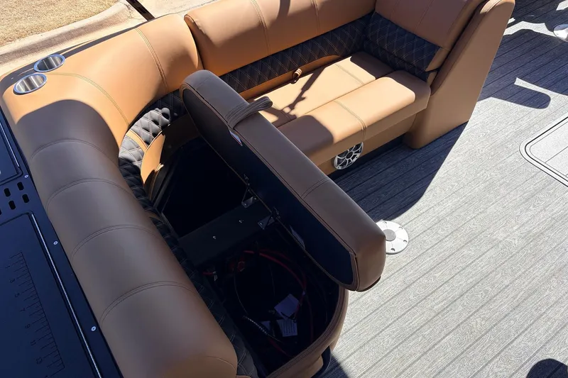 Slide: The Image of 2026 Ranger 223FC boat interior with tan seating, storage compartment, and cup holders. - 25