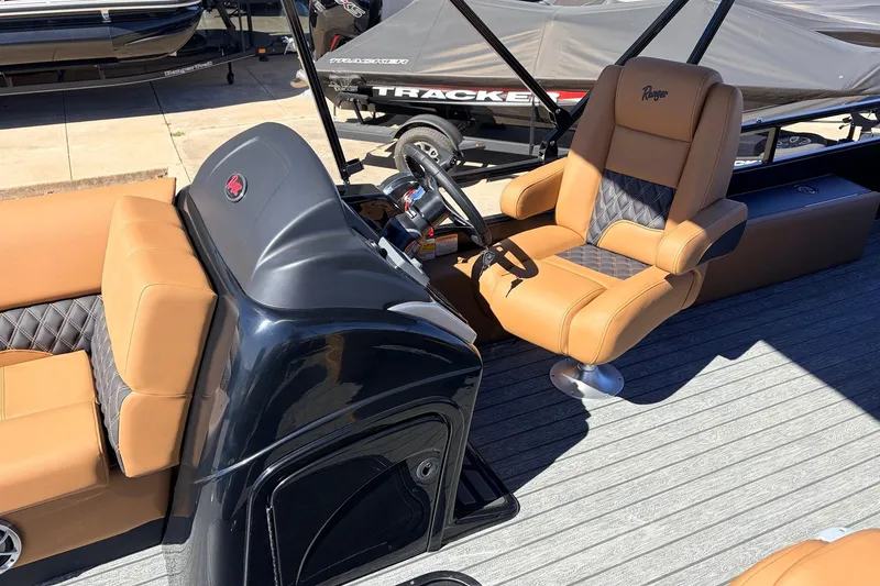 Slide: The Image of 2026 Ranger 223FC boat interior with tan and black seating, steering console, and deck. - 28