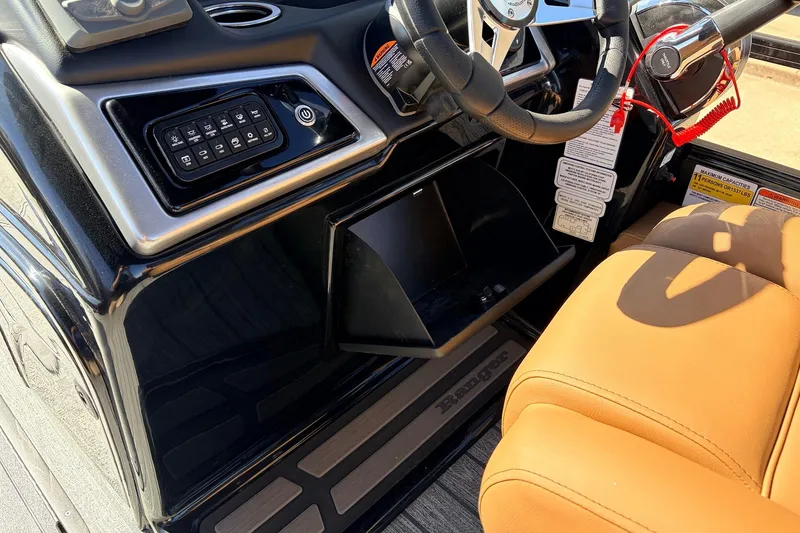 Slide: The Image of 2026 Ranger 223FC boat dashboard with control panel and tan seating. - 31