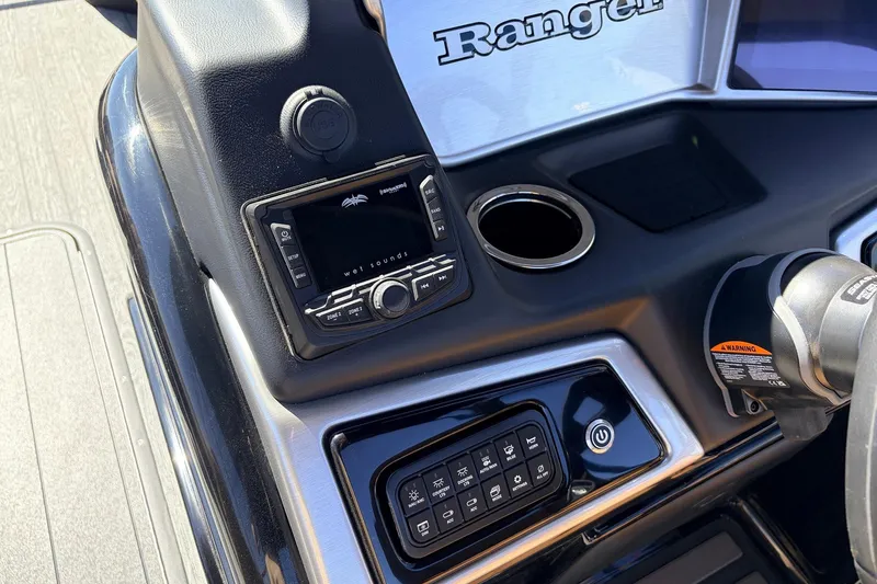 Slide: The Image of Control panel of 2026 Ranger 223FC boat with audio system and cup holder. - 33