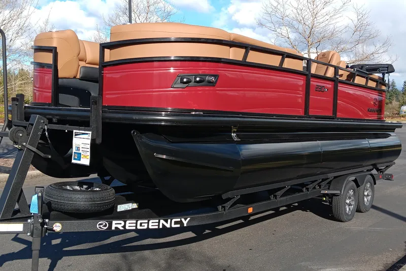The Image of 2026 Regency 230 DL pontoon boat on trailer, featuring red and black design. - 0