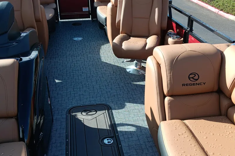 Slide: The Image of Luxurious interior of 2026 Regency 230 DL boat with tan leather seating and carpeted floor. - 11