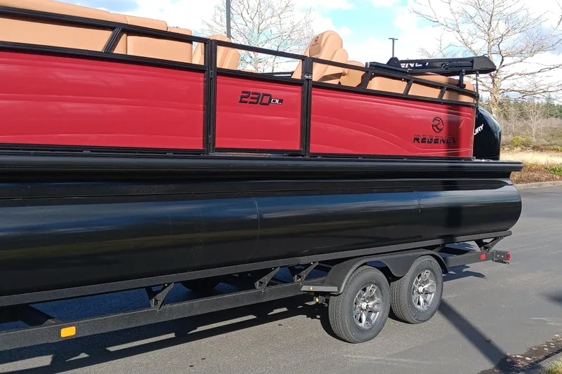 Slide: The Image of 2026 Regency 230 DL pontoon boat on trailer, featuring red and black design. - 5