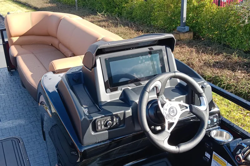 Slide: The Image of 2026 Regency 230 DL boat interior with steering console and tan seating. - 6