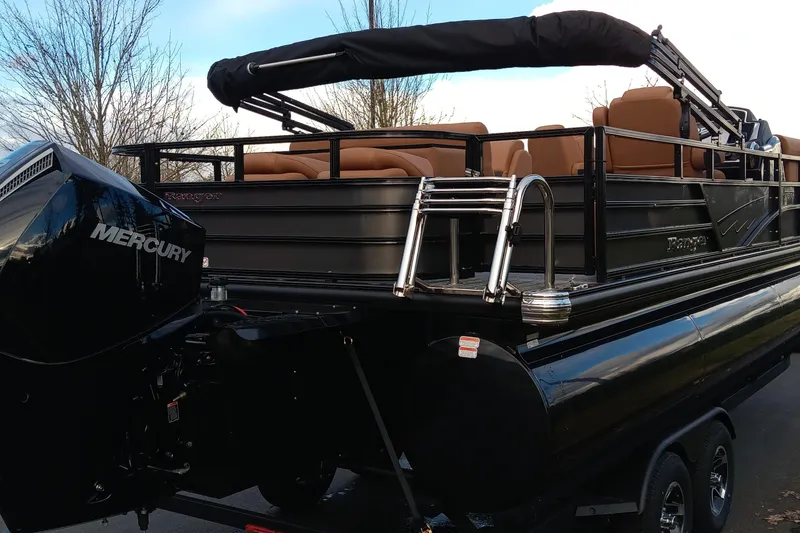 Slide: The Image of 2026 Ranger 223FC pontoon boat with Mercury engine, black exterior, and tan seating. - 9
