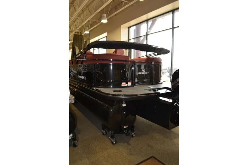 Slide: The Image of 2026 Regency 230 DL pontoon boat displayed indoors, featuring sleek black design. - 3
