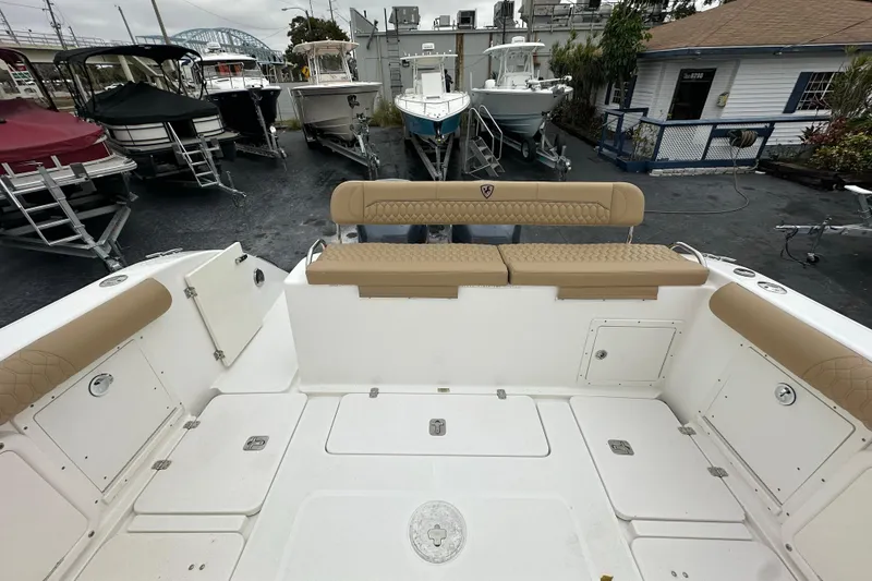 Slide: The Image of 2007 Century 3200 Center Console boat interior with tan seating, docked among other boats. - 11