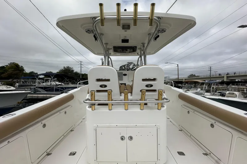 Slide: The Image of 2007 Century 3200 Center Console boat with rod holders and seating, docked under cloudy skies. - 13