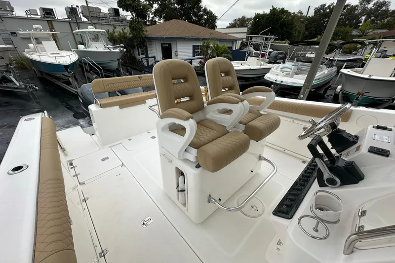Slide: The Image of 2007 Century 3200 Center Console boat with tan seating and steering wheel, docked among other boats. - 16