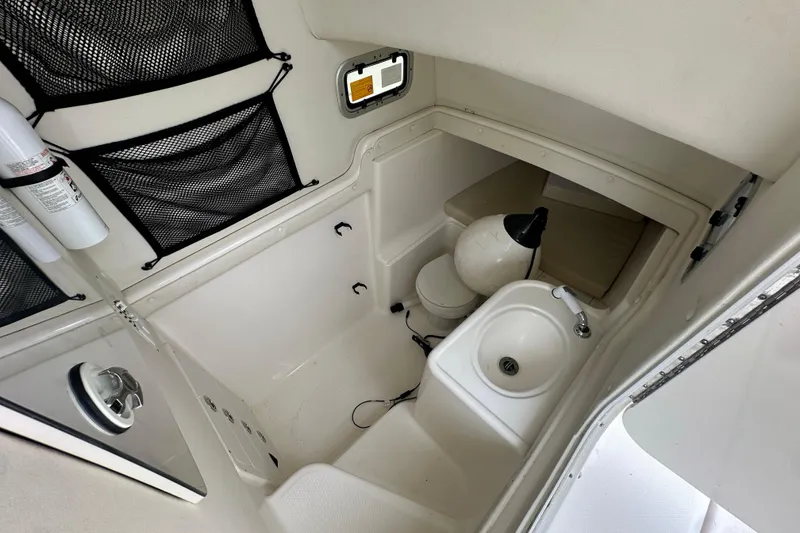 Slide: The Image of 2007 Century 3200 Center Console boat interior with sink, toilet, and storage. - 23