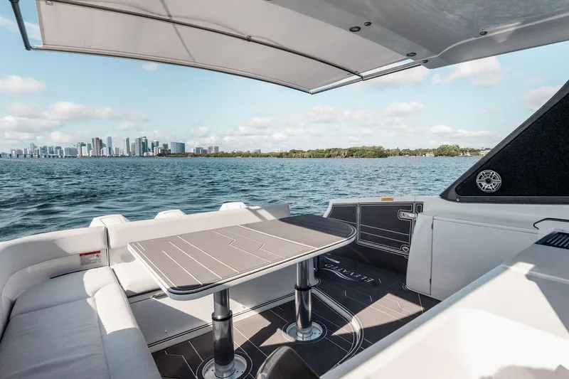 Slide: The Image of 2025 Azimut Verve 42 yacht interior with city skyline view, featuring sleek seating and table. - 11