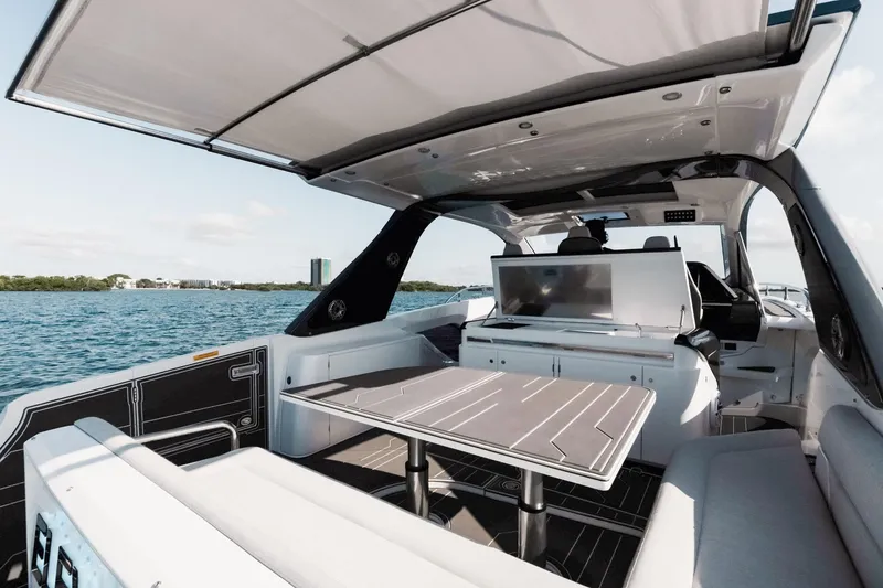 Slide: The Image of Luxurious 2025 Azimut Verve 42 yacht interior with sleek seating and table, overlooking serene waters. - 13