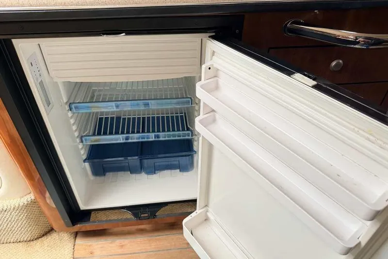 Slide: The Image of Open refrigerator inside a 2007 Sea Ray 340 Sundancer yacht, showing empty shelves and door compartments. - 35