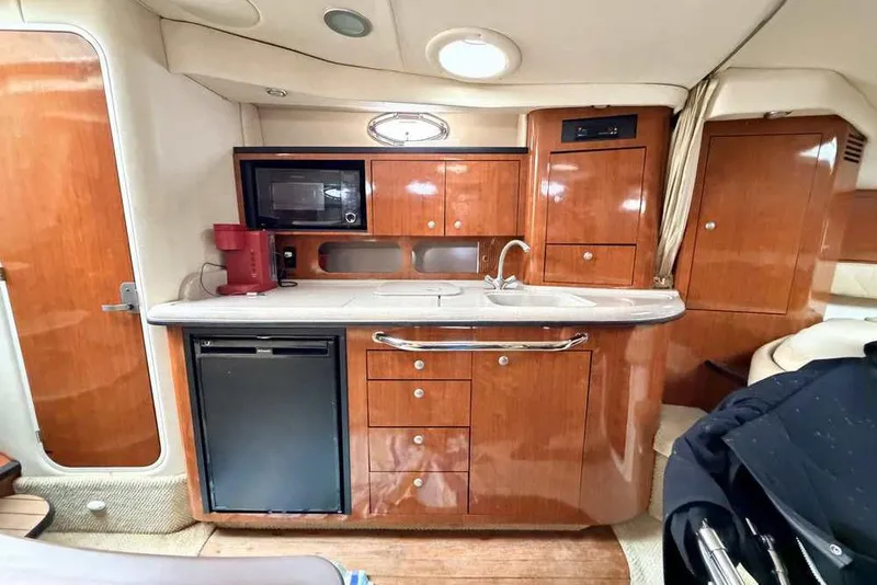 Slide: The Image of 2007 Sea Ray 340 Sundancer interior kitchen with wood cabinetry, sink, microwave, and mini-fridge. - 38