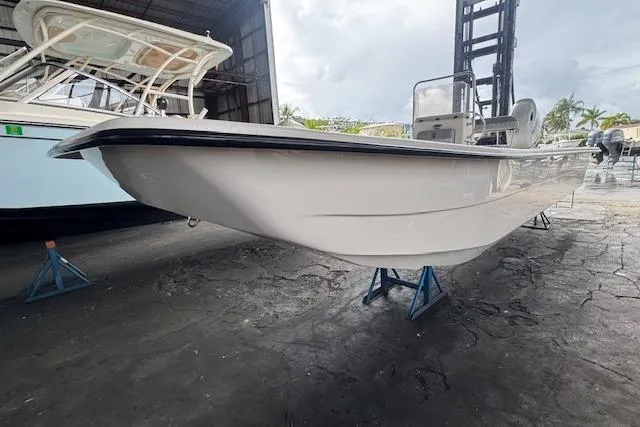 Slide: The Image of 2026 Carolina Skiff E24 DLX CC boat in storage, side view. - 12