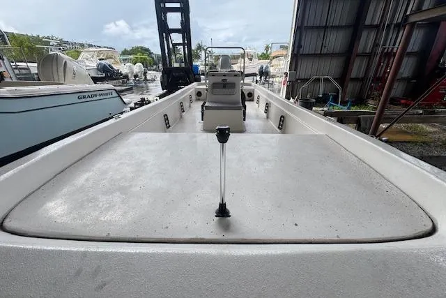 Slide: The Image of 2026 Carolina Skiff E24 DLX CC boat docked, showcasing spacious deck and center console. - 13