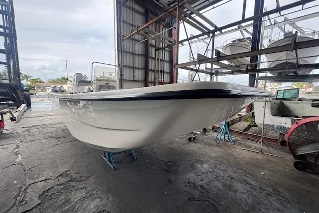 Slide: The Image of 2026 Carolina Skiff E24 DLX CC boat in a warehouse, elevated on stands. - 14