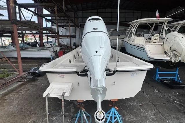 Slide: The Image of 2026 Carolina Skiff E24 DLX CC boat in storage, rear view with outboard motor. - 5