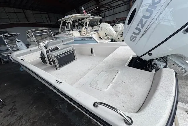 Slide: The Image of 2026 Carolina Skiff E24 DLX CC boat with Suzuki engine in a storage facility. - 7