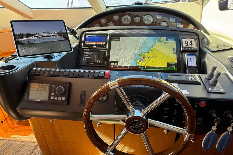 Slide: The Image of Control panel of a 2005 Sunseeker 75 Yacht with navigation screens and steering wheel. - 10