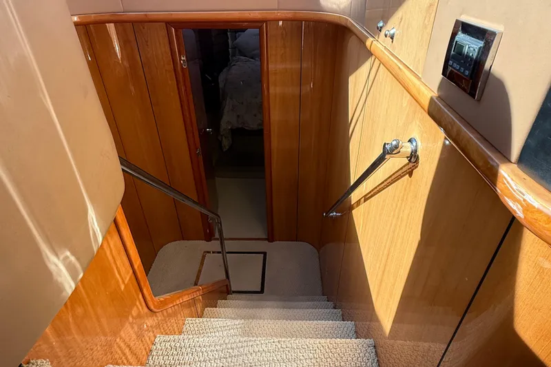 Slide: The Image of Staircase inside 2005 Sunseeker 75 Yacht, featuring wooden paneling and carpeted steps. - 12