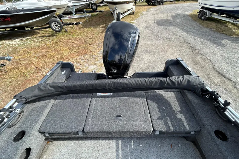 Slide: The Image of 2021 Lund 1675 Adventure SS boat interior with motor, parked among other boats. - 16