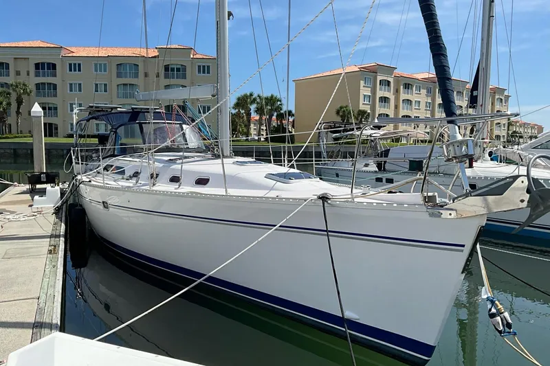 The Image of Catalina 470 sailboat from 2000 docked at a marina with waterfront buildings. - 0